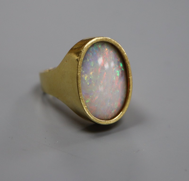 A modern 18ct gold and oval white opal set dress ring, size J, gross 8.4 grams.